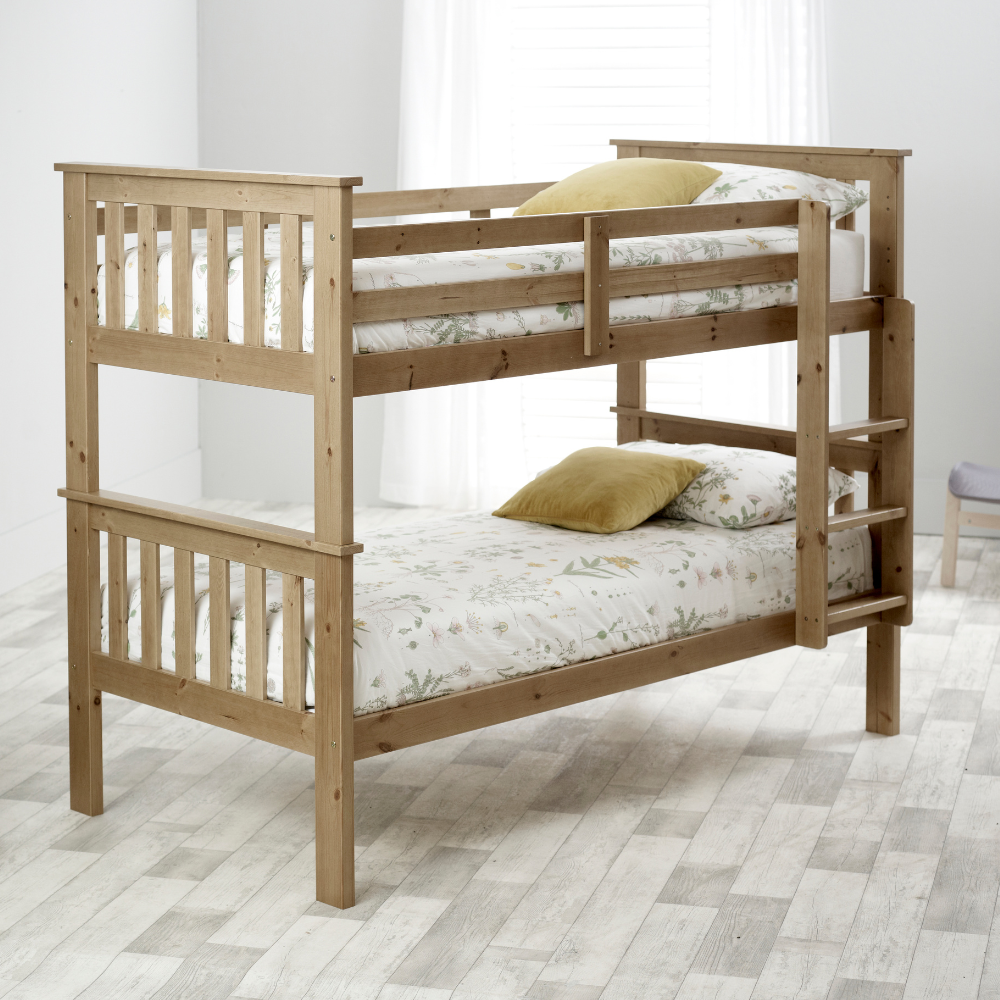Wooden bunk bed with floral bedding in a room setting
