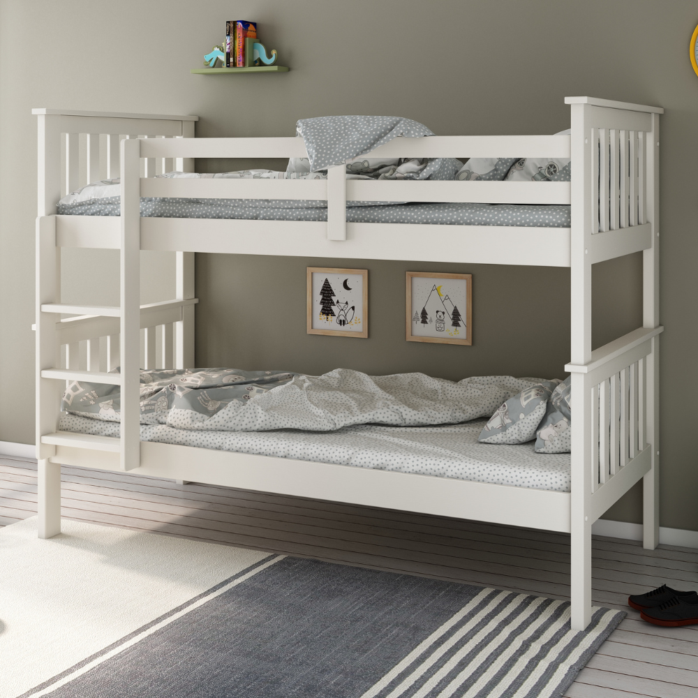 White bunk bed with grey bedding in a room with a grey wall and rug.