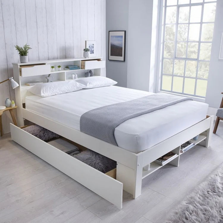 White bed with storage drawers in a bright bedroom