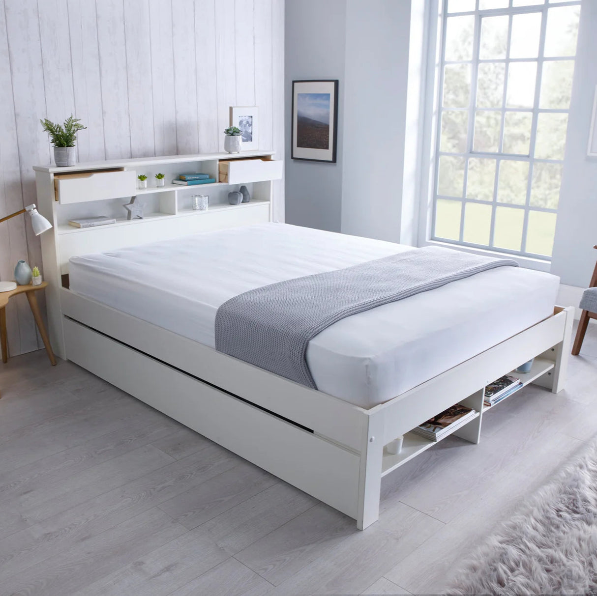 White bed with storage drawers in a bright bedroom