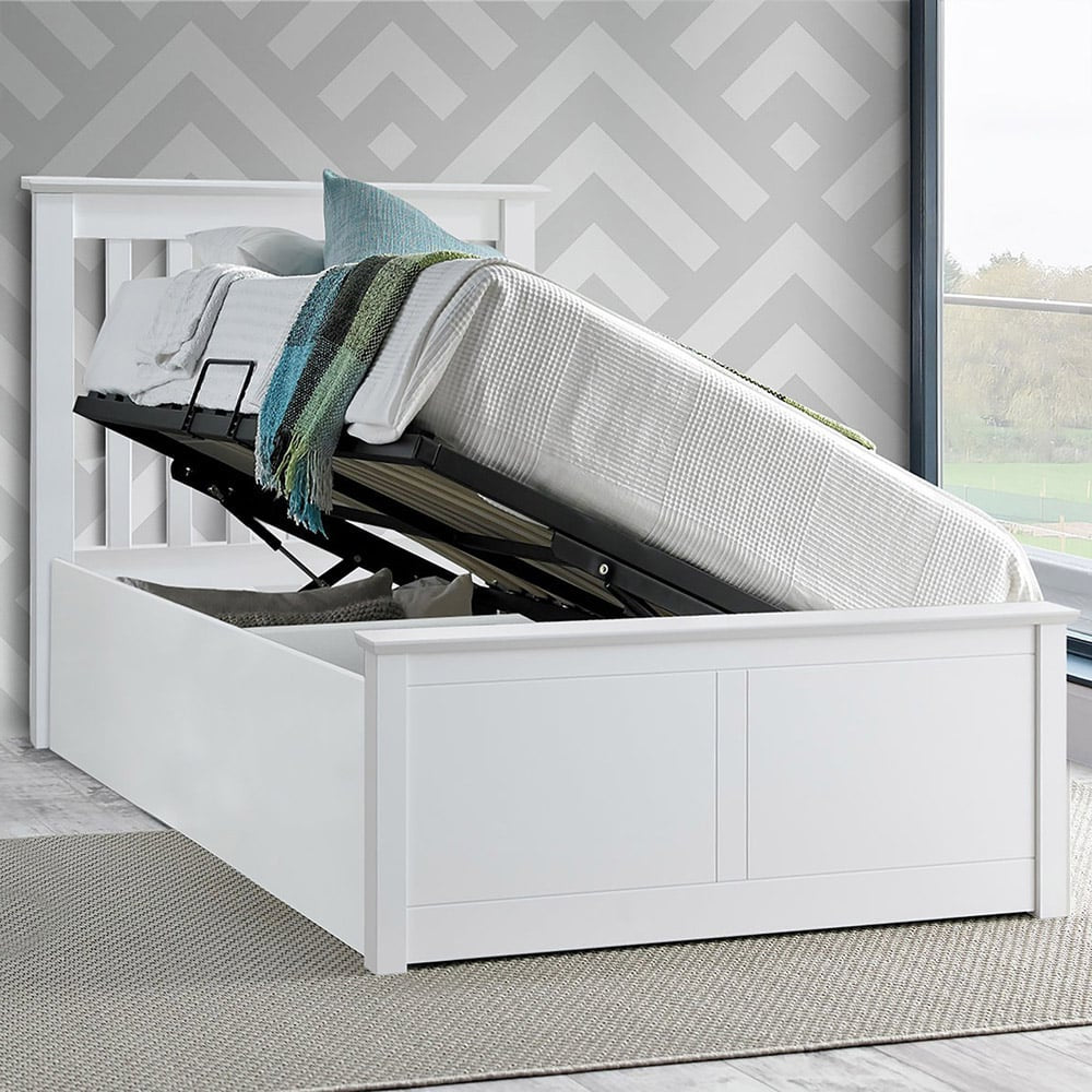 White bed with storage drawers open against a grey and white geometric-patterned wall.