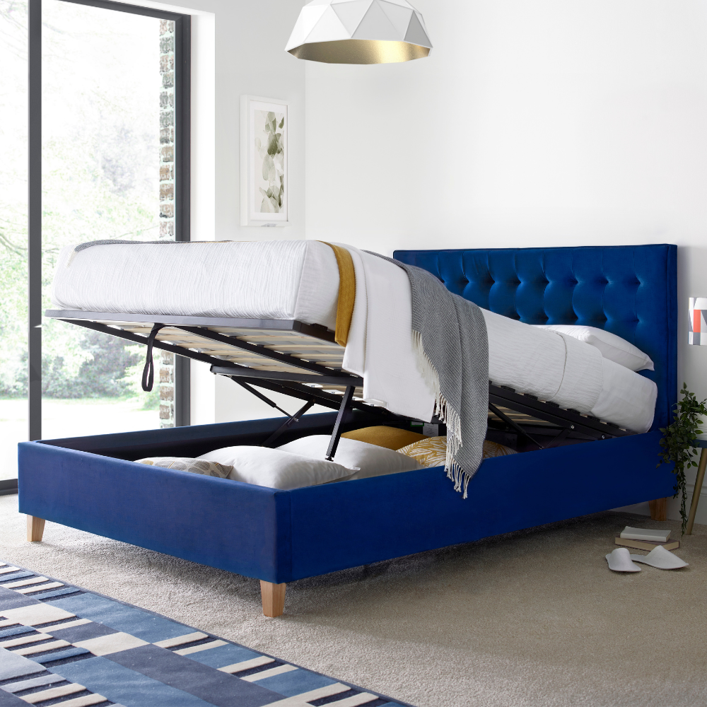 Blue upholstered bed with storage compartments in a modern bedroom.