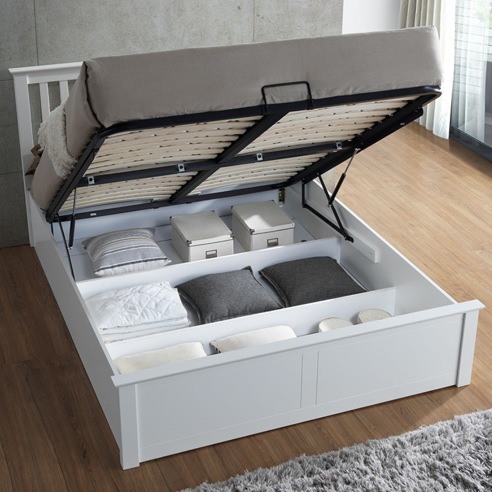 White bed with storage compartments on a wooden floor.