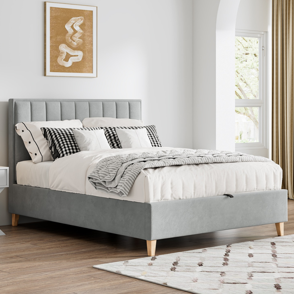 Grey upholstered bed with white bedding in a bedroom setting.