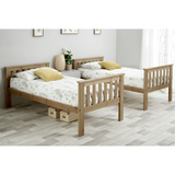 Two wooden beds with storage drawers in a room with a light gray floor and white walls.