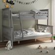 A grey bunk bed in a childs bedroom with a green painted wall. 