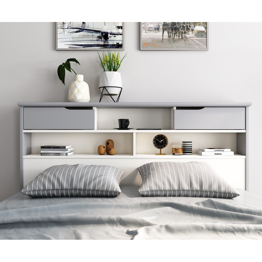 Bedroom with a bed featuring striped pillows, a headboard with shelves, and decorative items.