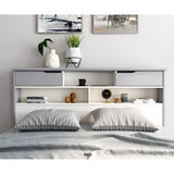 Bedroom with a bed featuring striped pillows, a headboard with shelves, and decorative items.