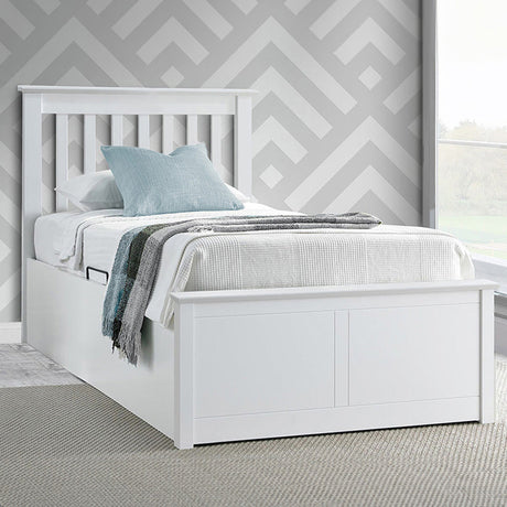 White bed with grey bedding against a geometric-patterned wall