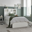 White bed with bookshelves in a bedroom setting
