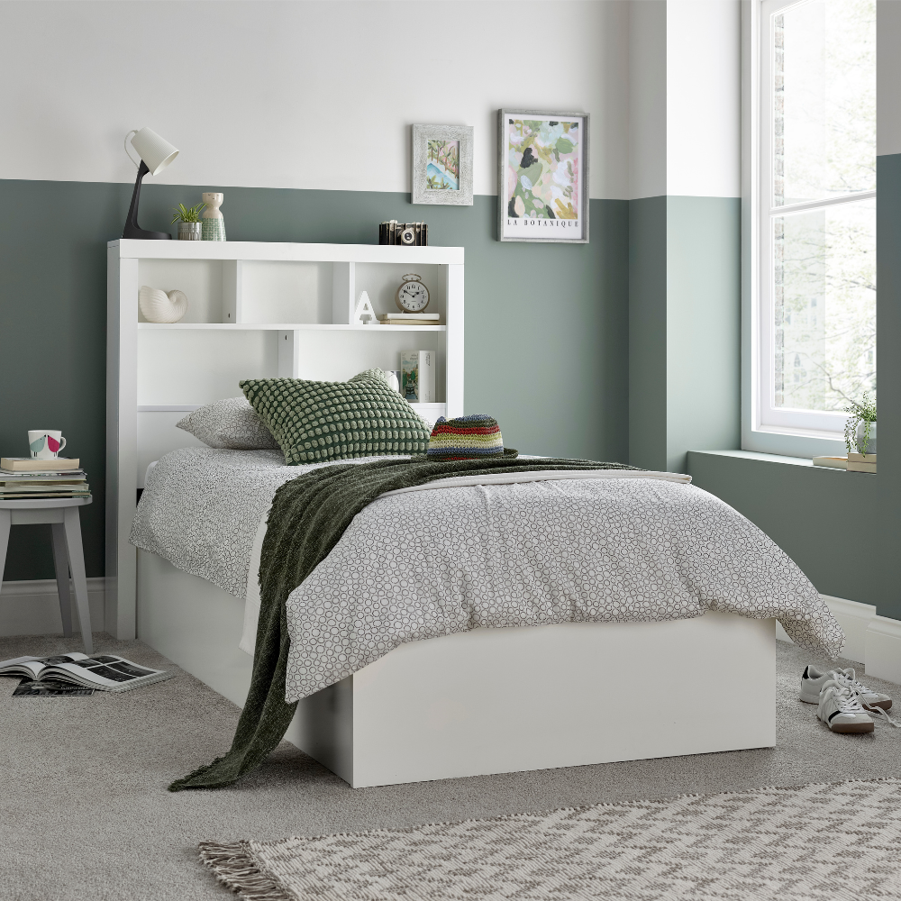 White bed with bookshelves in a bedroom setting