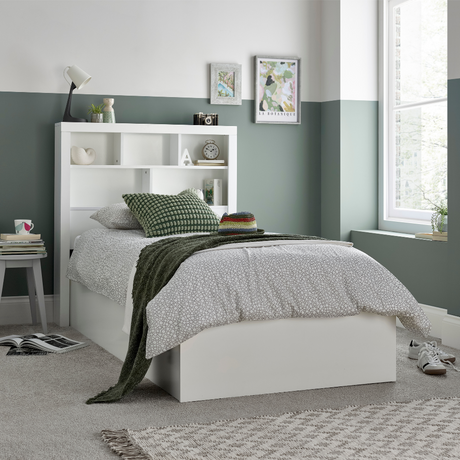 White bed with bookshelves in a bedroom setting
