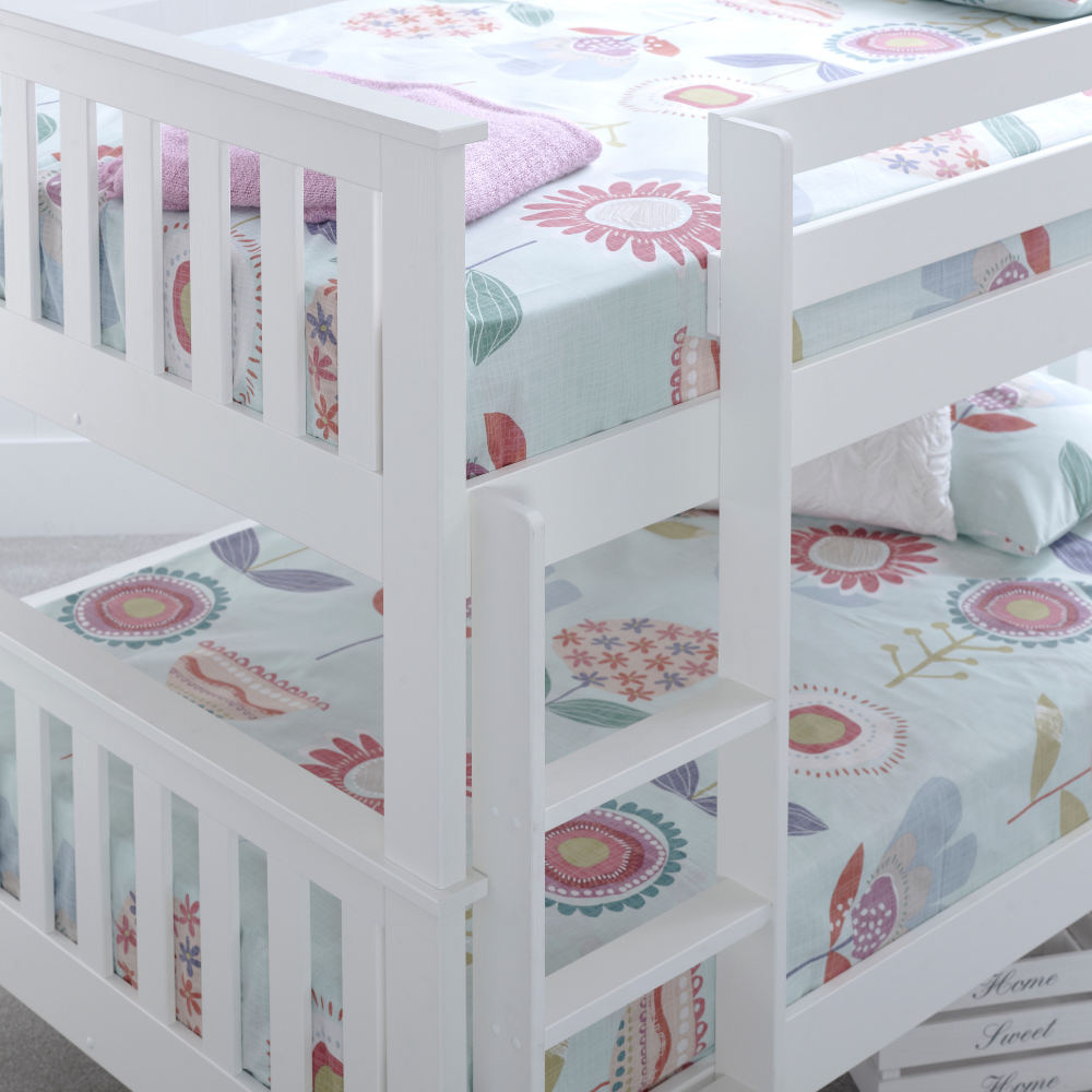 White bunk bed with floral-patterned bedding in a child's room.